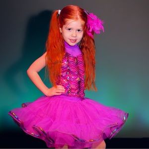 The outfit and hair piece and there are purple bows for shoes,